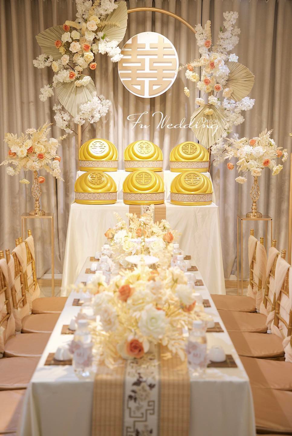 Trang trí gia tiên màu be nhã nhặn với hoa màu cam nâu và điểm nhấn là bộ tráp cưới vàng ánh kim dành cho cô dâu mạng Kim.  - Facebook